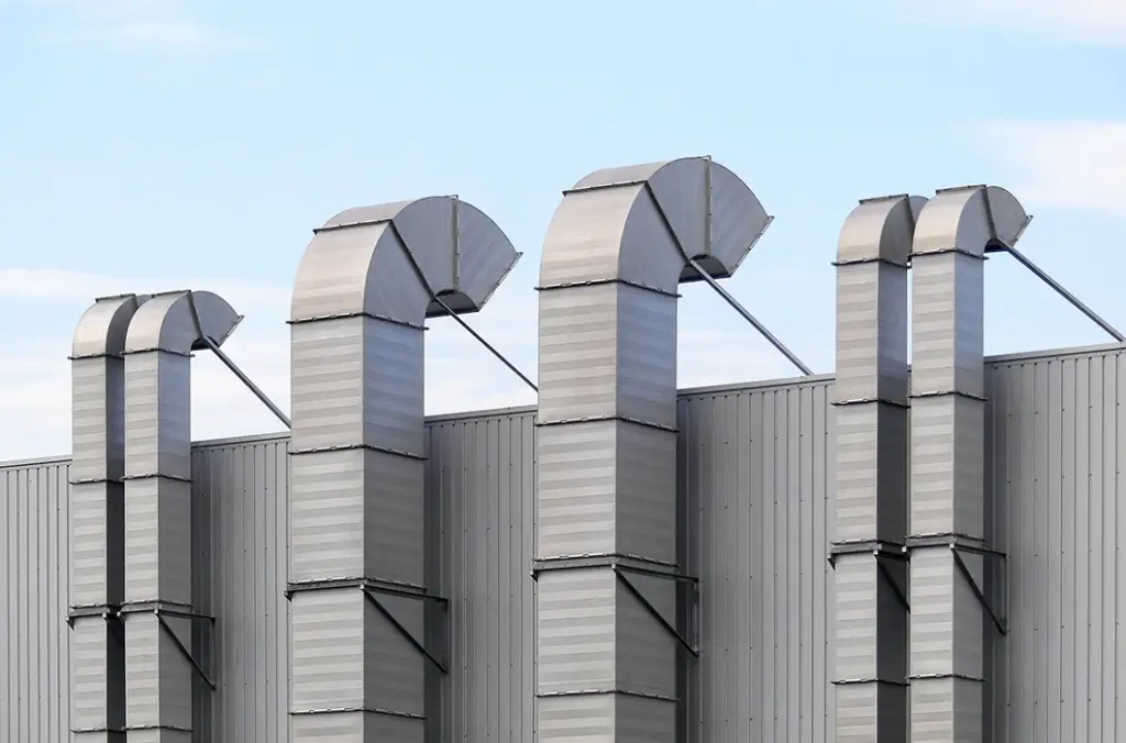 工場または建物の屋上にある複数の大きな角型換気ダクト（排気筒）