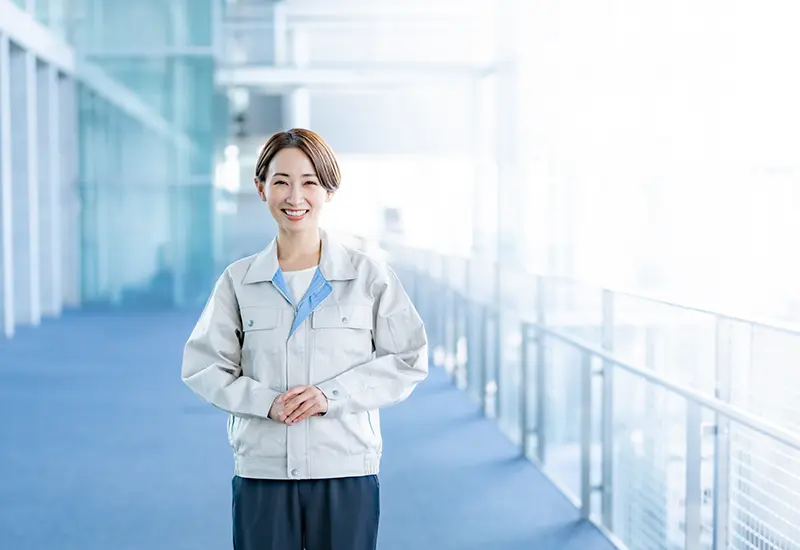 作業服を着て笑顔で立つスタッフ